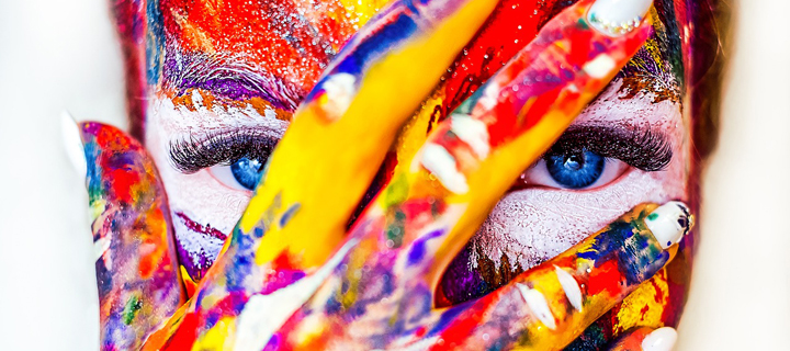 woman with painted hands over face