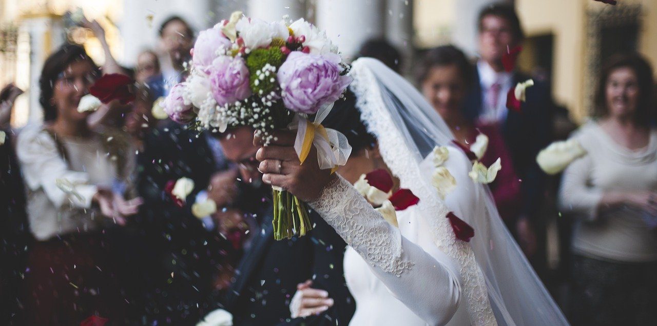 Bride holding flowers and rice thrown at wedding